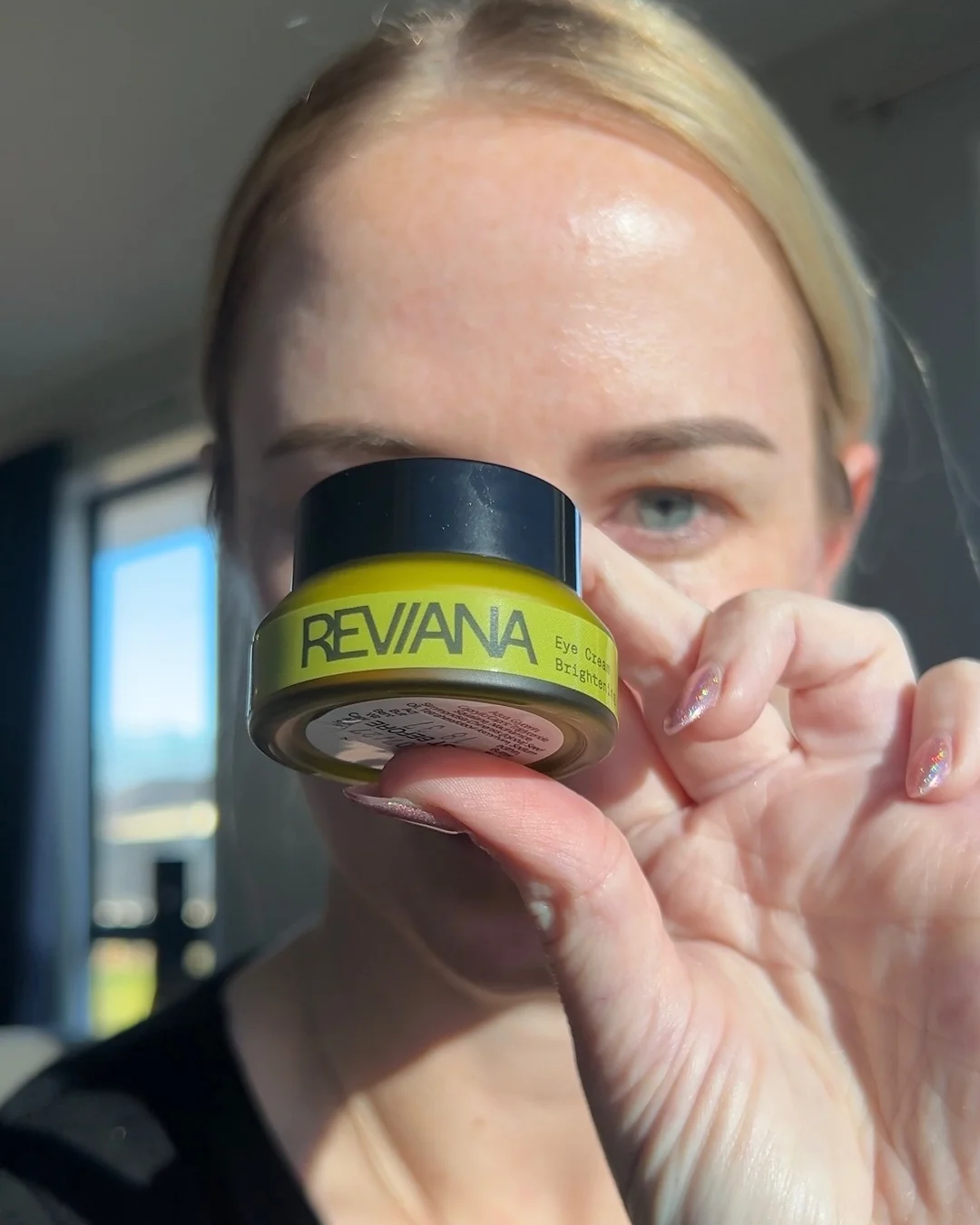 Reviana Eye Cream held beside the eye